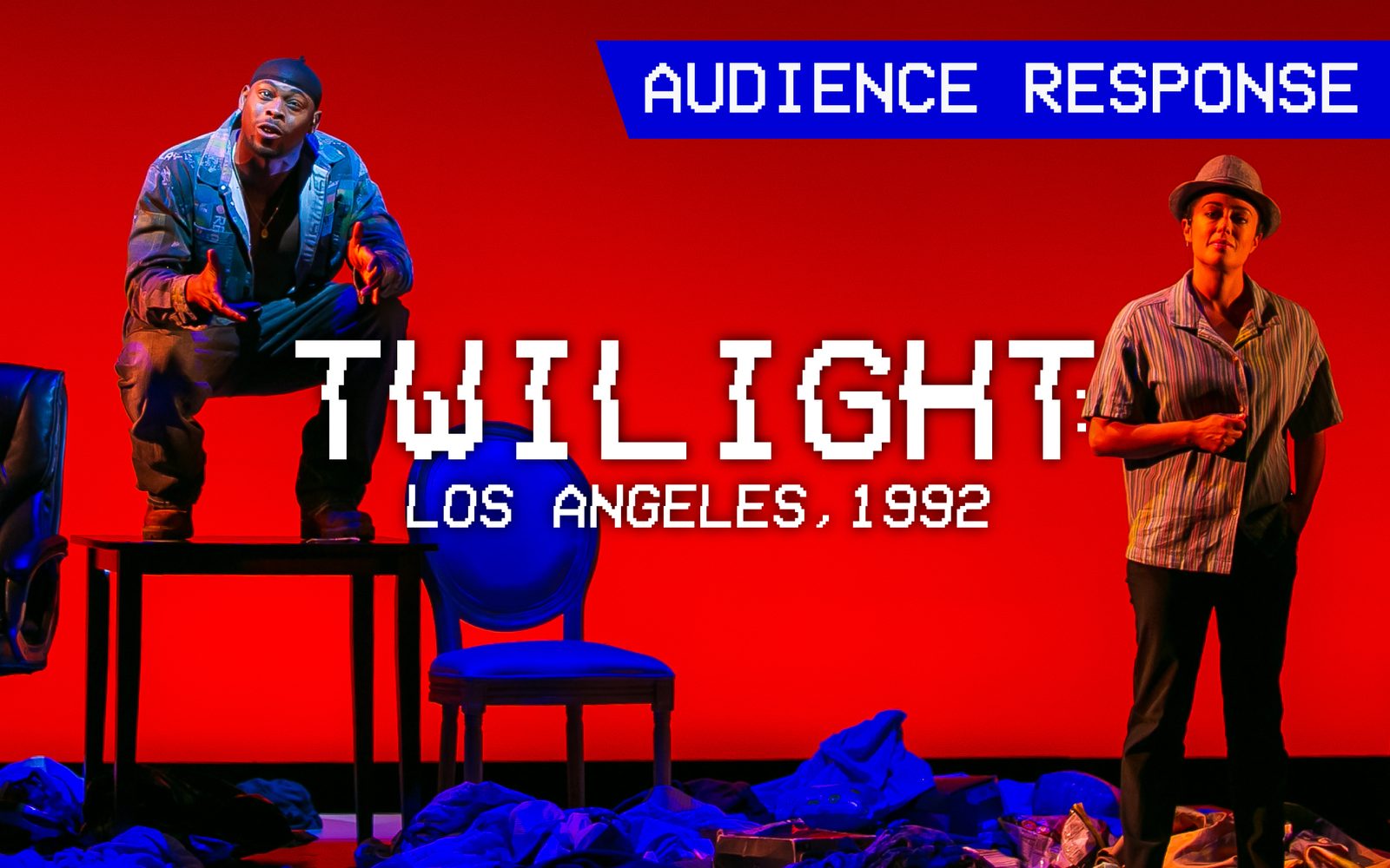 Wesley T. Jones in a patched denmic jacket, jeans, and a durag squats on a table between chairs, while Elena Hurst in a striped button-down and fedora stands to the right. With Text 