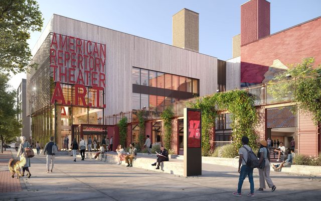 The exterior of the building during the daytime, with plants growing over the walls of the outdoor performance yard.