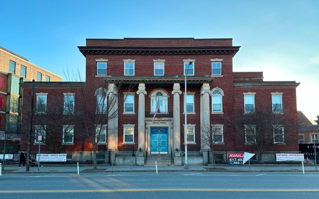 Cambridge Masonic Temple The Cambridge Masonic Temple, a brick building with four white columns at the front on a cloudless day.
